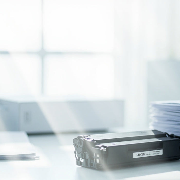 Stack of paper sheets and printer supplies on a desk in an office
