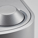 A macro photo focuses on the texture of the metallic finish and precision of the single button and indicator.